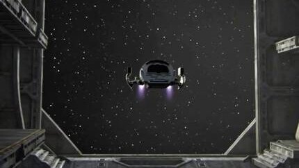 Still: the puddle jumper flying into the freighter’s open hangar bay, seen from inside, stars beyond the doors